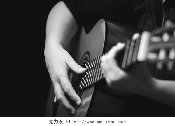 原声吉他细节音乐家的手弹奏经典吉他隔离在黑色